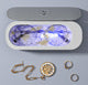 Gold rings, necklace and earrings inside the cleaner water tank with a blue light